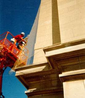 Image of two men in a lift installing bird netting to keep pigeons from roosting.